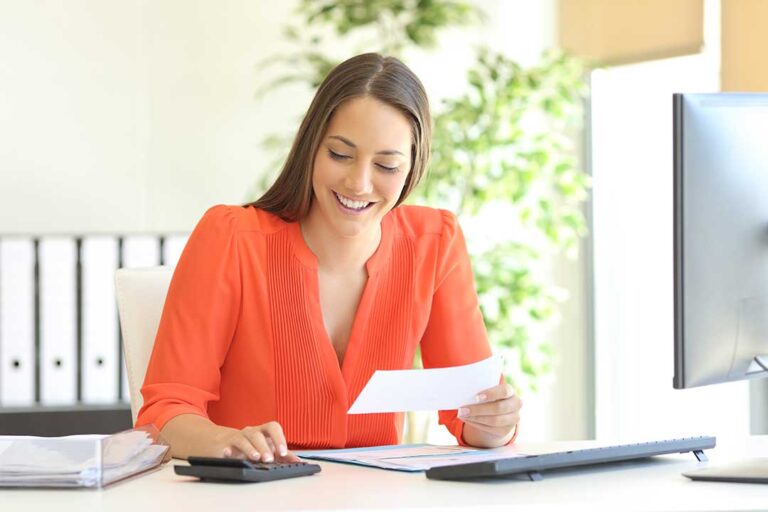 Taxpayer reviewing an IRS notice beside organized folders, receipts, and financial records on a desk.