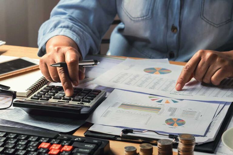 A family reviews grocery receipts, utility bills, and a handwritten household budget at a kitchen table.